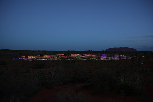 Do crepúsculo para a noite, as hastes e círculos luminosos passam a brilhar em um contraste lindo com o deserto Foto Voyages